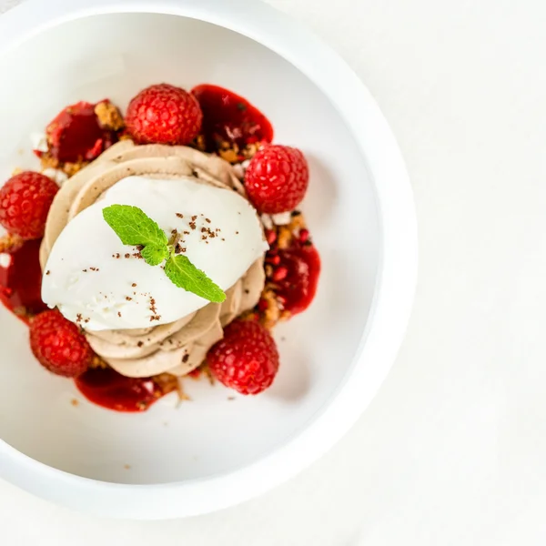 Le foto dell’Elgus Nature Retreat Dessert con mousse, panna, lamponi e foglia di menta in piatto bianco