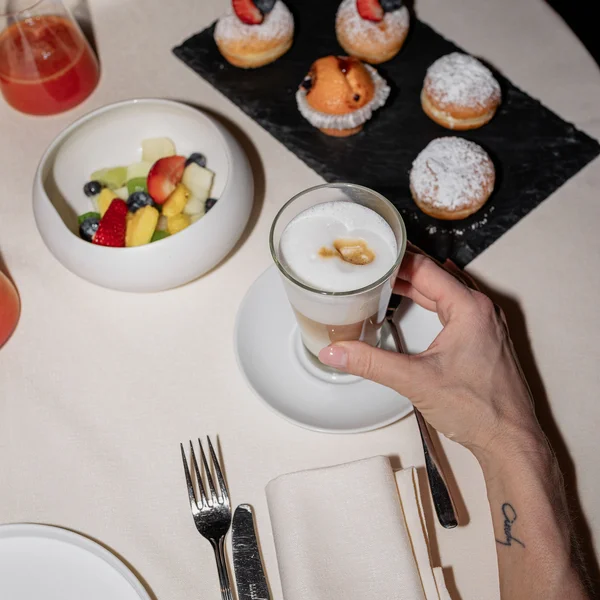 Le foto dell’Elgus Nature Retreat Colazione con caffè latte, frutta fresca e dolcetti su tovaglia bianca