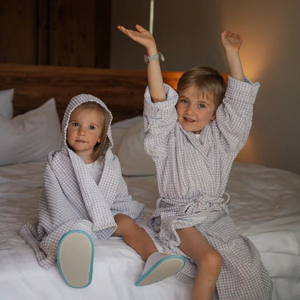 Le foto dell’Elgus Nature Retreat Due bambini in accappatoi seduti su un letto in una stanza d'albergo