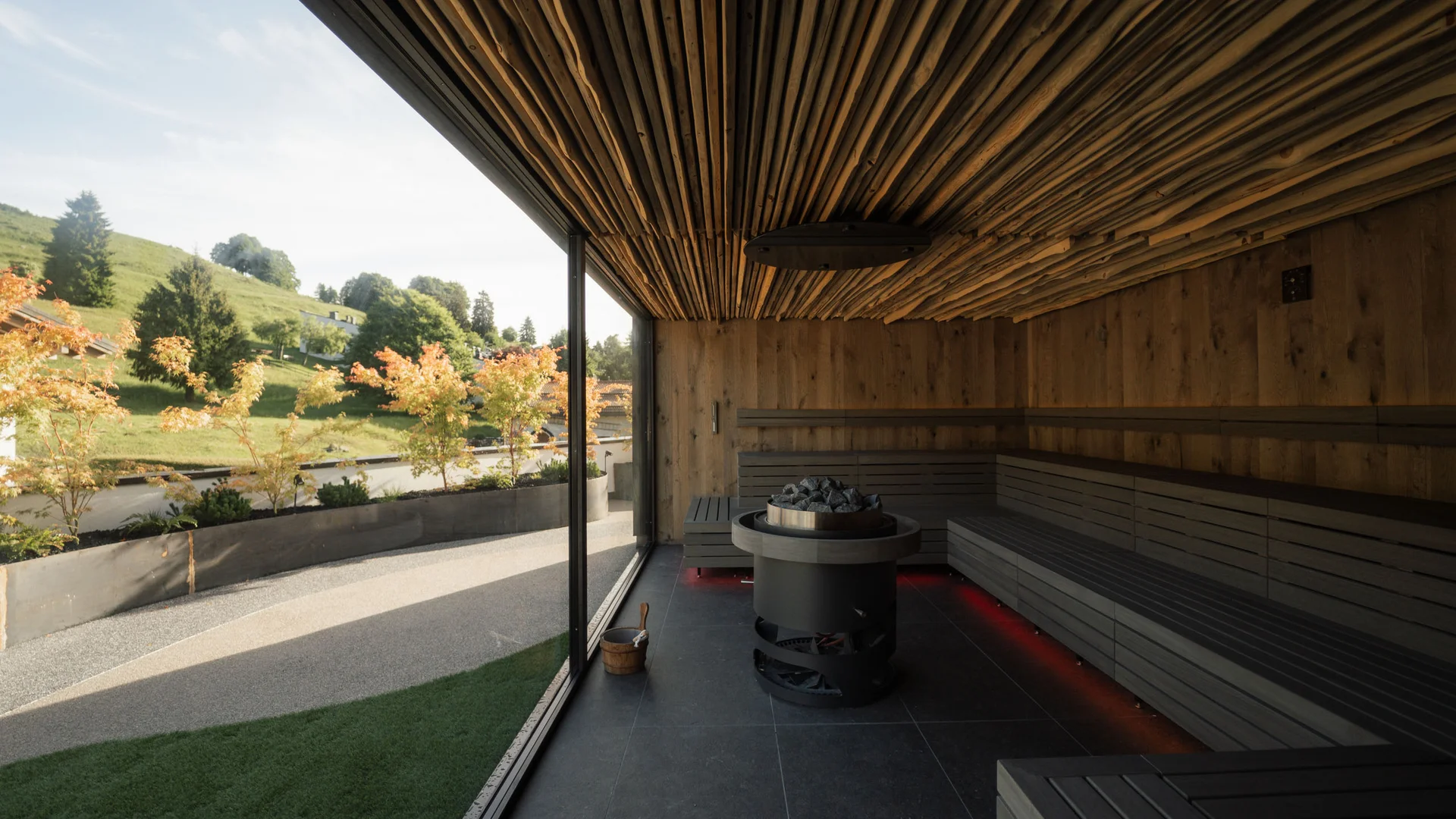Elgus: hotel a 4 stelle in Trentino Sauna moderna con pareti in legno e vista panoramica sul paesaggio esterno