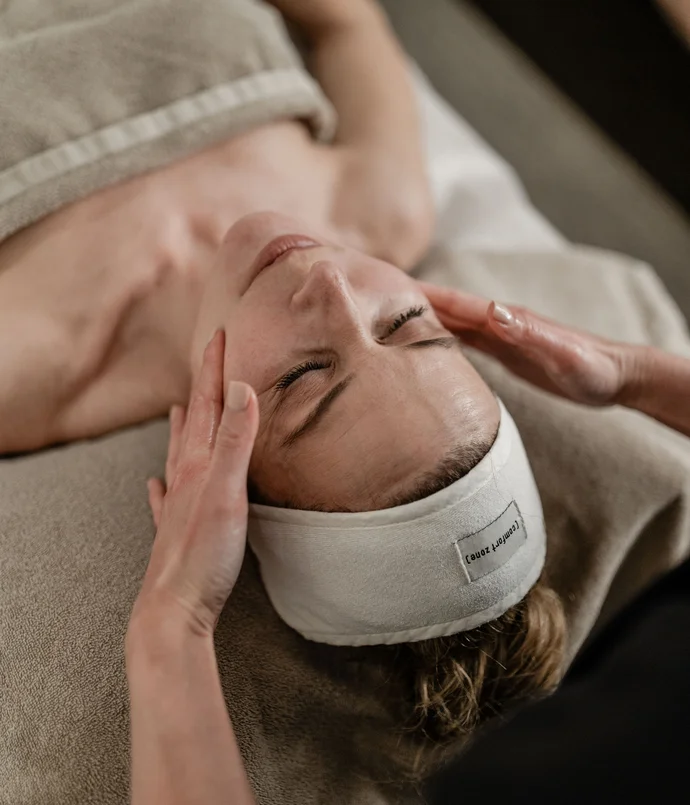Trattamenti e massaggi in Trentino Donna rilassata che riceve un massaggio al viso in una spa