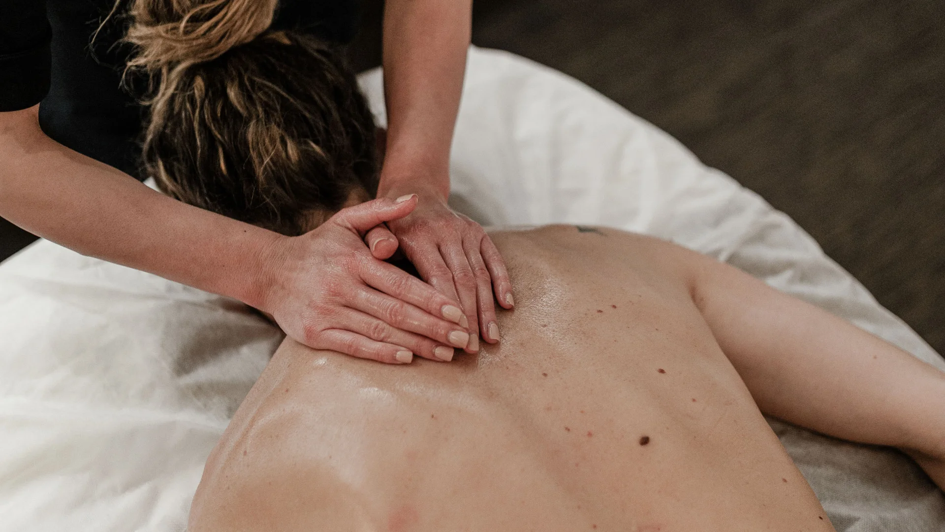 Trattamenti e massaggi in Trentino massaggiatrice che fa un massaggio alla schiena a una persona sdraiata