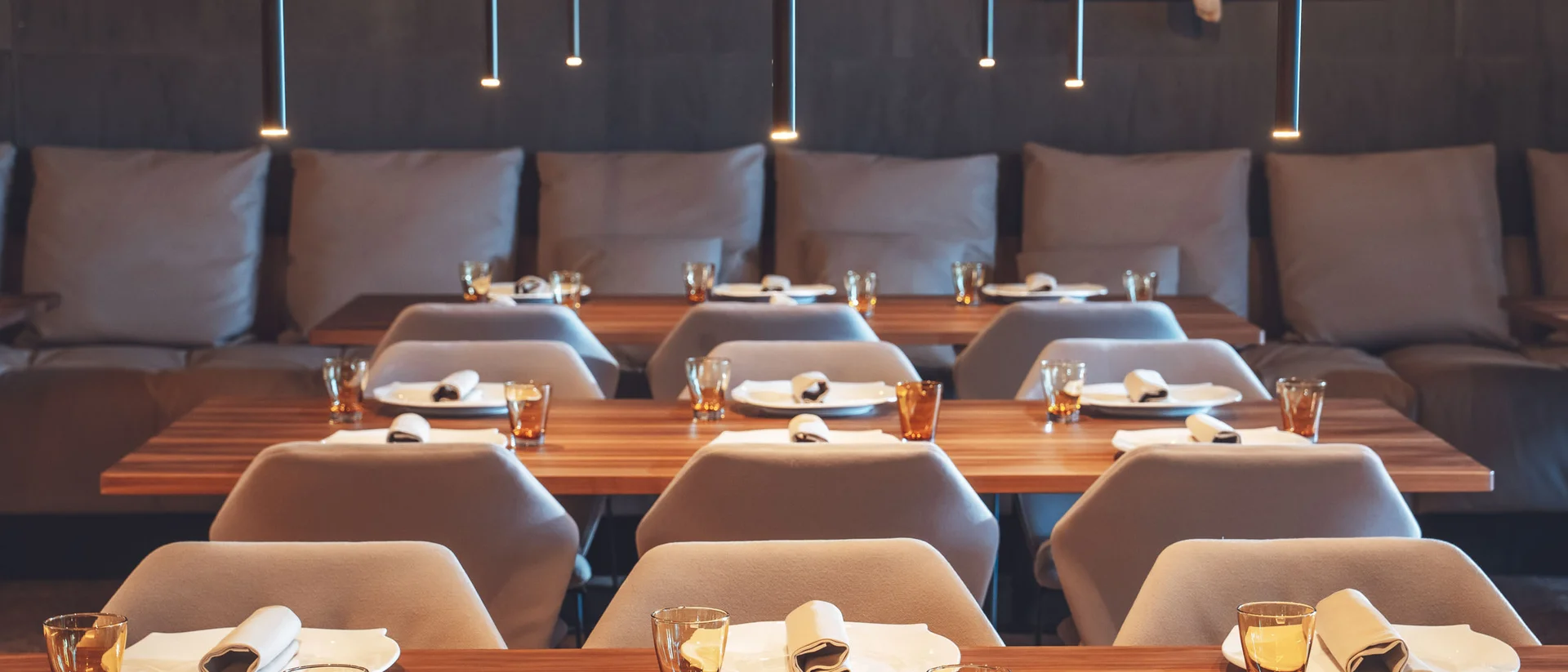 Il nostro ristorante a San Giacomo, Brentonico Tavoli apparecchiati con piatti, bicchieri e tovaglioli in un ristorante moderno