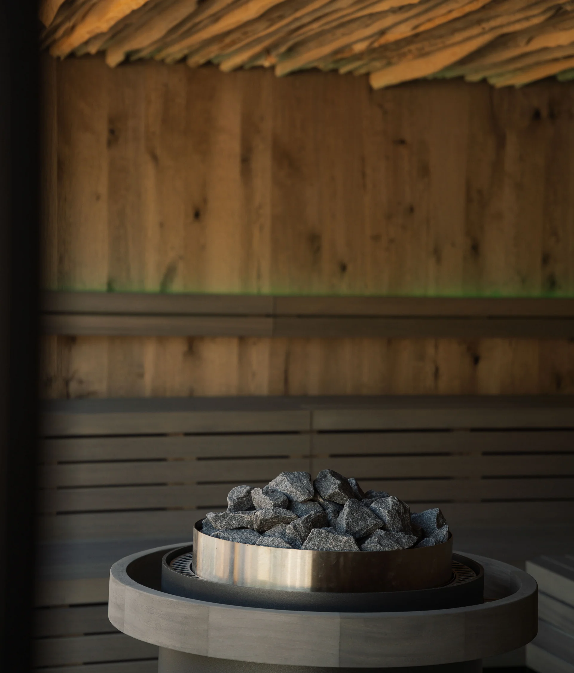 Day spa in Trentino, all’Elgus Stufa con pietre in una sauna con pareti di legno