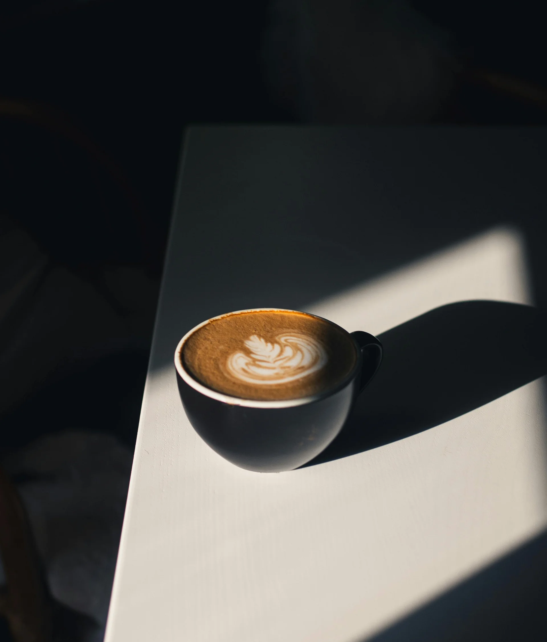 Lounge bar e bistrot a San Giacomo Tazza di caffè con latte art su un tavolo bianco illuminato dal sole