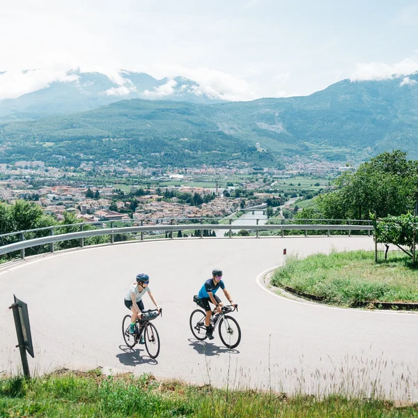 Le foto dell’Elgus Nature Retreat Due ciclisti su strada curva con vista panoramica su città e montagne