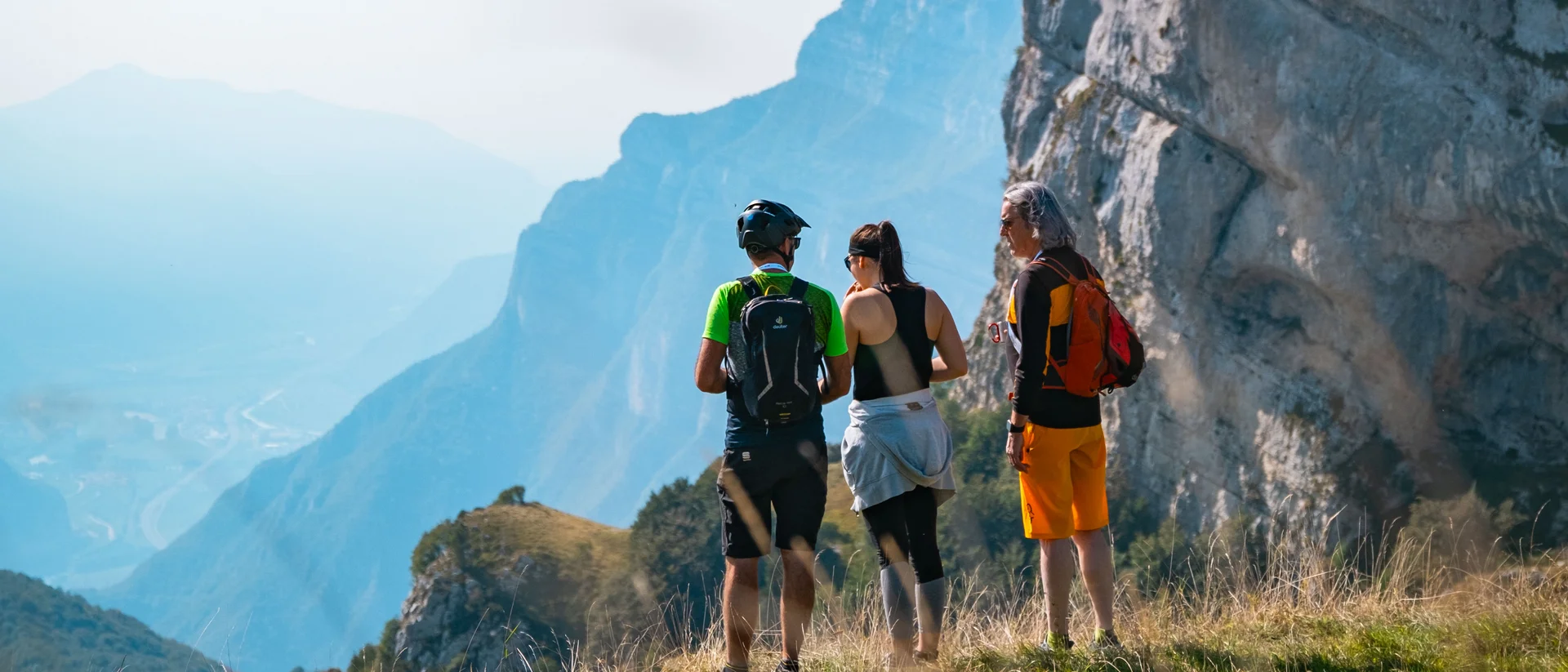 Tutto il divertimento di un hotel sul Monte Baldo Tre escursionisti con zaini su un sentiero di montagna con vista panoramica
