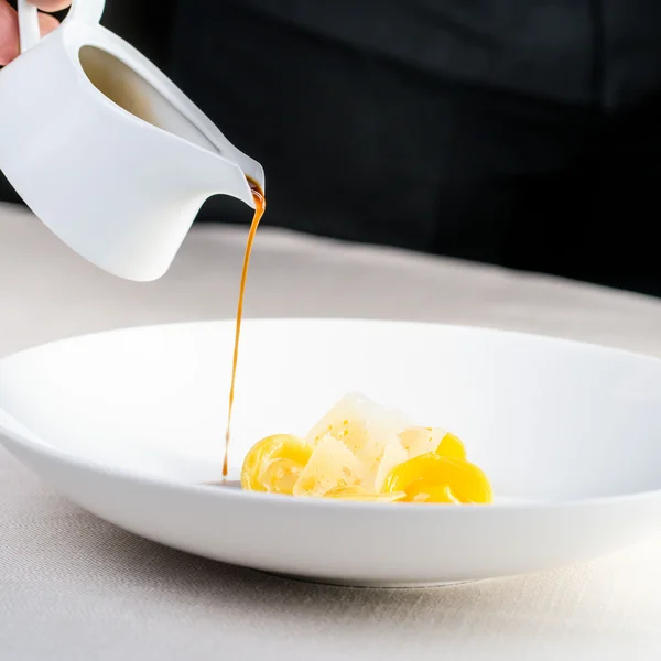 Le foto dell’Elgus Nature Retreat Salsa versata da una brocca bianca su un piatto con pasta e formaggio
