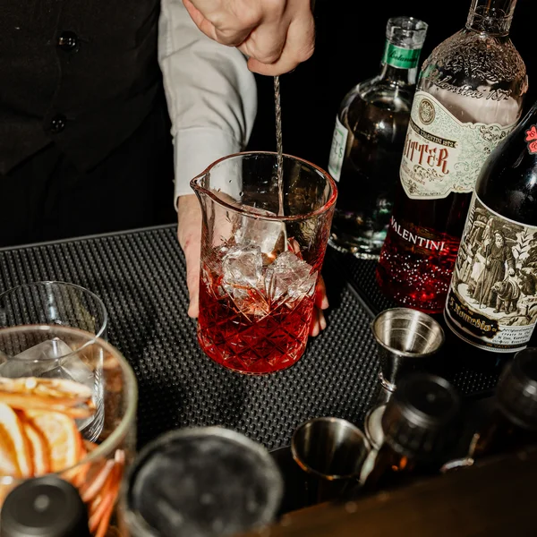 Le foto dell’Elgus Nature Retreat Bartender che mescola un cocktail rosso con ghiaccio in un mixing glass
