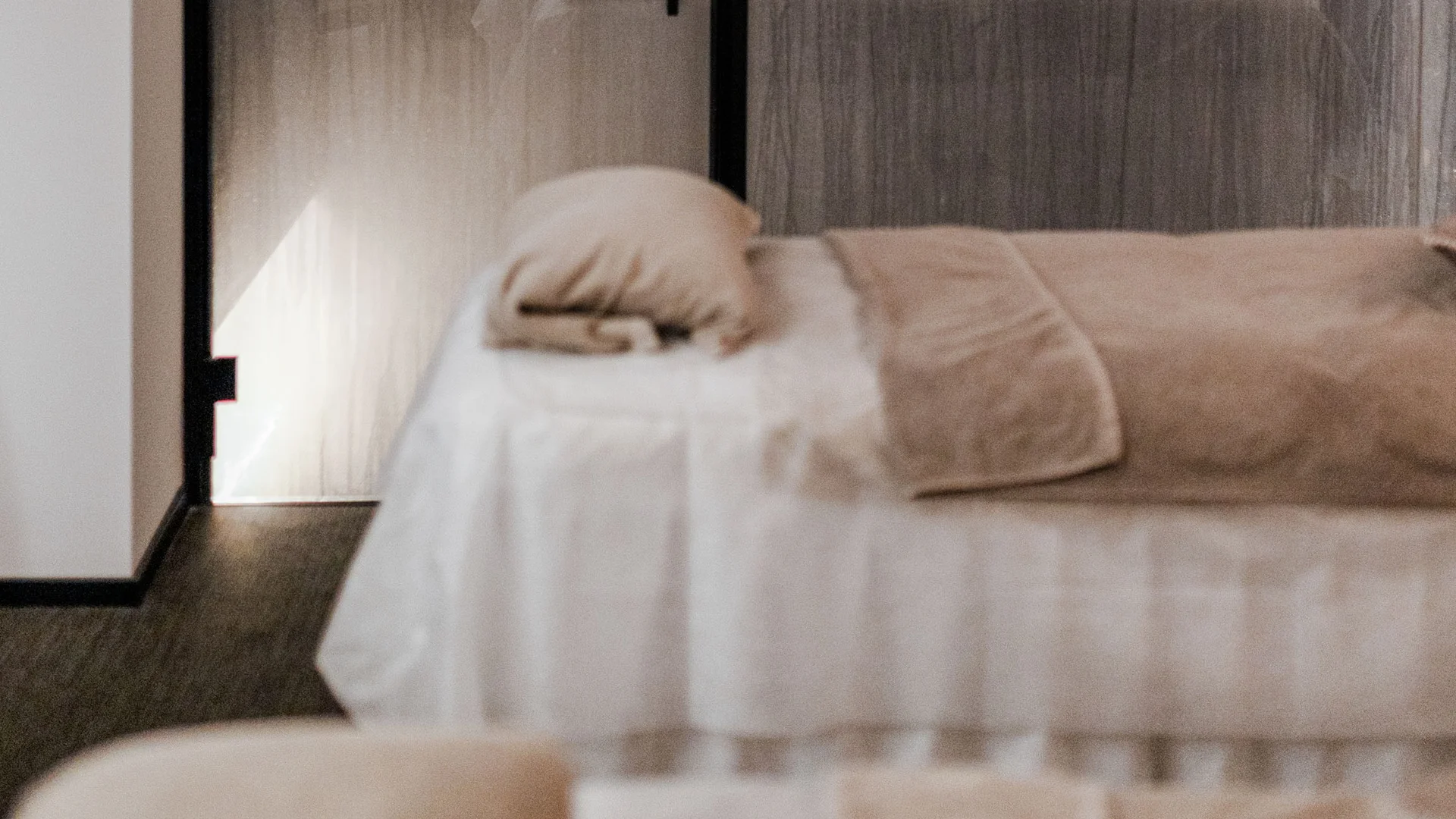 Trattamenti e massaggi in Trentino Letto da massaggio in stanza rilassante con pareti di vetro opaco