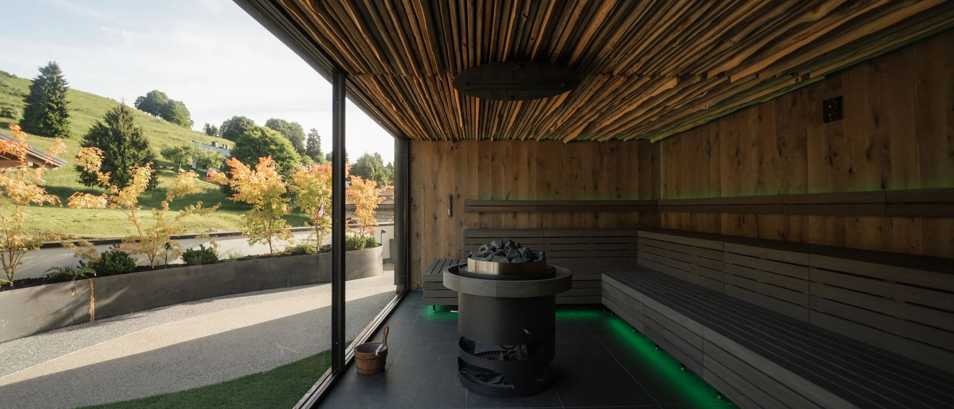 Elgus: hotel con spa a Brentonico Interno di una sauna moderna con pareti in legno e vista panoramica esterna