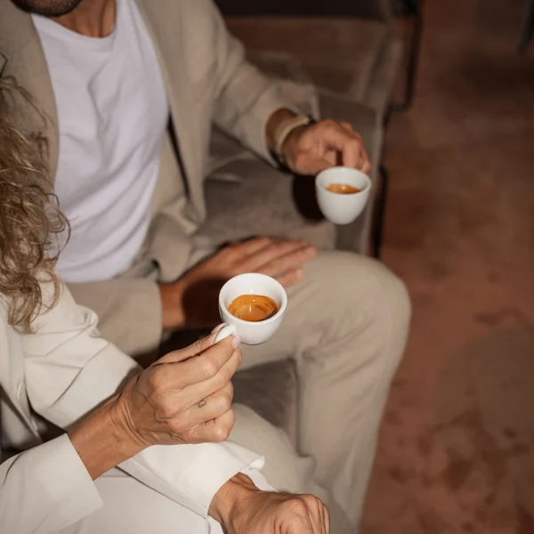 Le foto dell’Elgus Nature Retreat Due persone sedute su un divano che tengono tazzine di caffè espresso