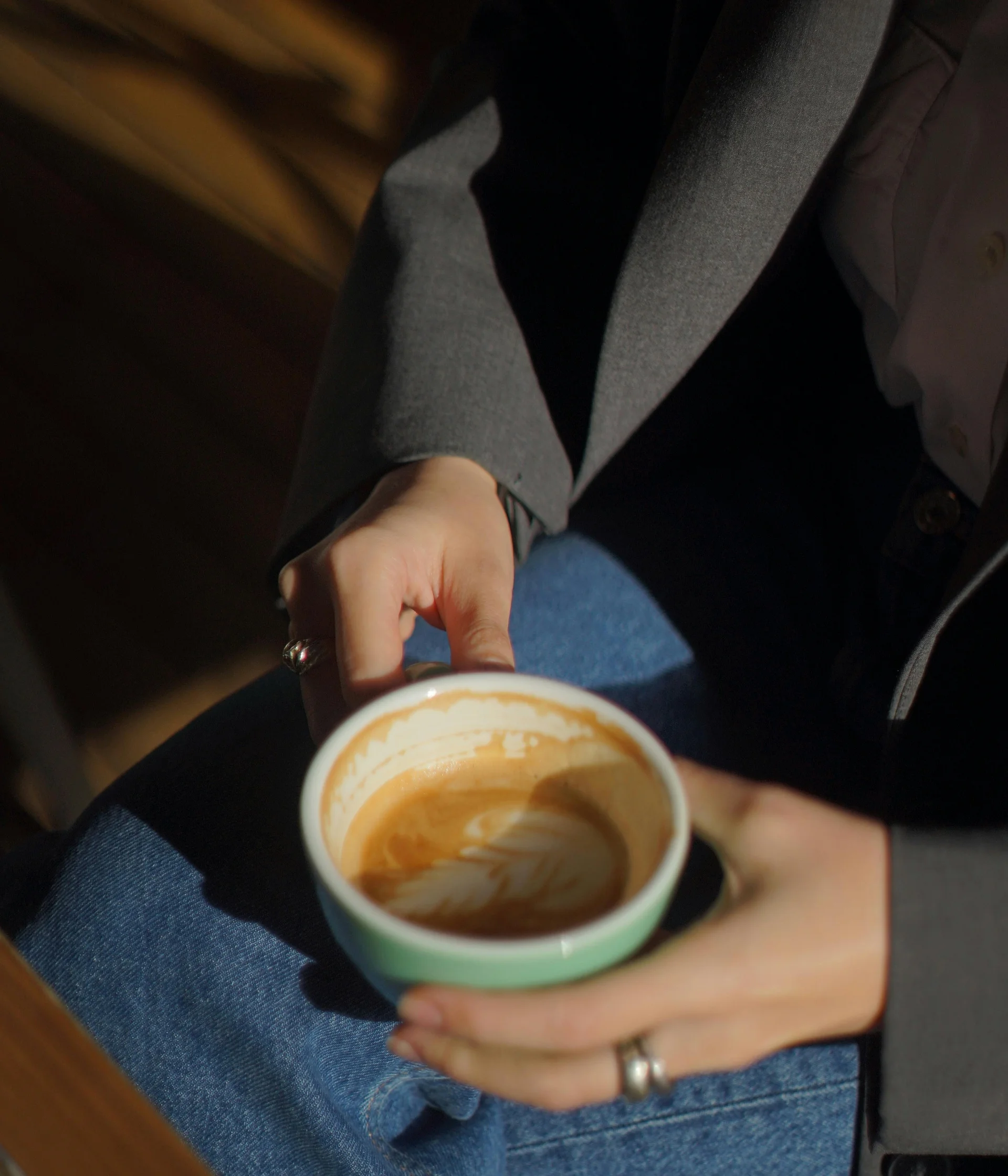 Il nostro ristorante a San Giacomo, Brentonico Persona che tiene una tazza di caffè quasi vuota seduta con jeans e giacca grigia