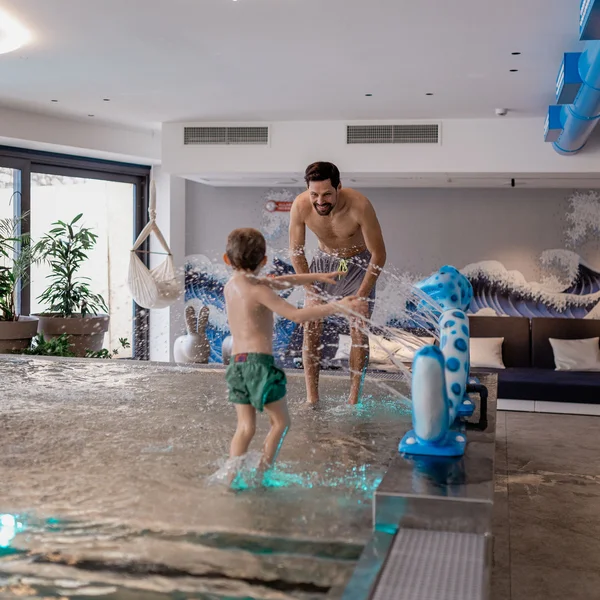 Le foto dell’Elgus Nature Retreat Bambino e uomo che giocano nell'acqua in piscina interna moderna