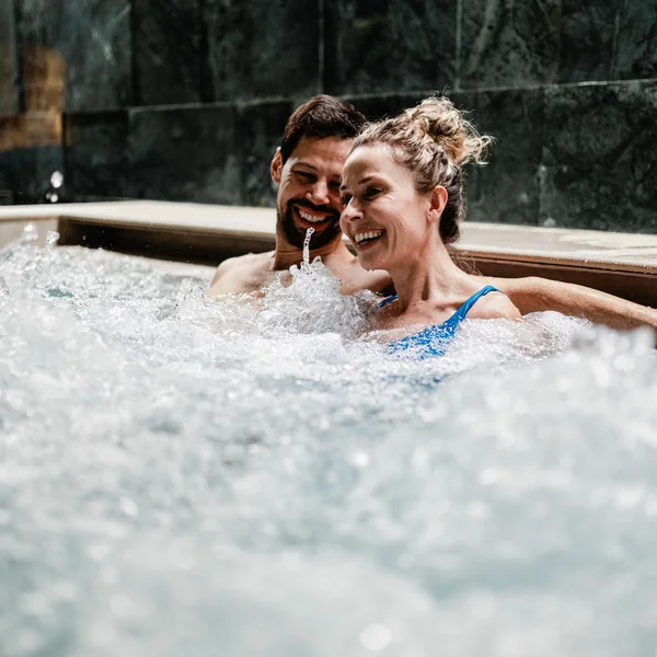 Le foto dell’Elgus Nature Retreat Coppia felice rilassata in una vasca idromassaggio con acqua frizzante