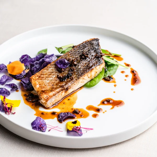 Le foto dell’Elgus Nature Retreat Filetto di pesce con patate viola, spinaci e salsa su piatto bianco