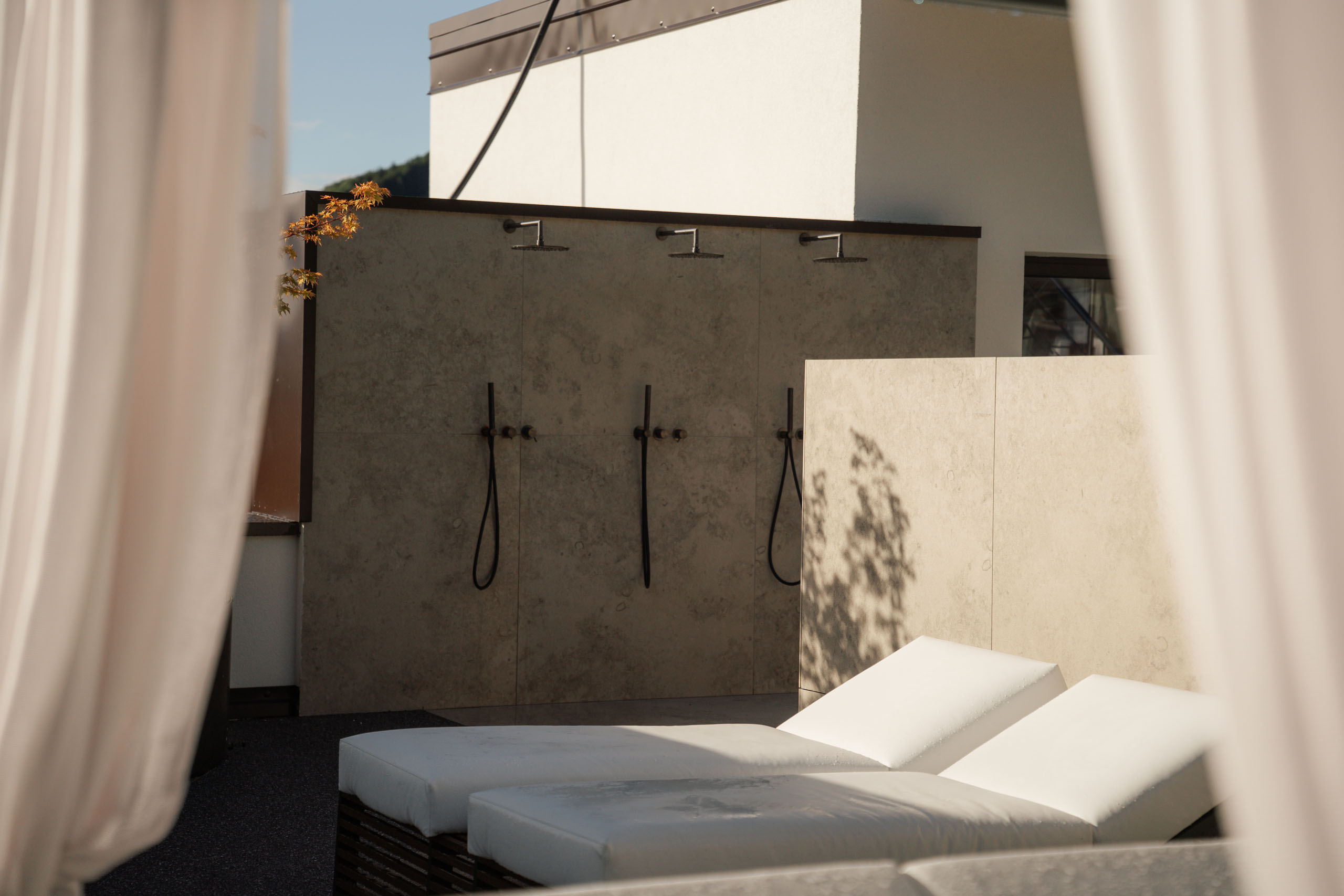 Le foto dell’Elgus Nature Retreat Lettini bianchi accanto a docce esterne in un'area relax all'aperto