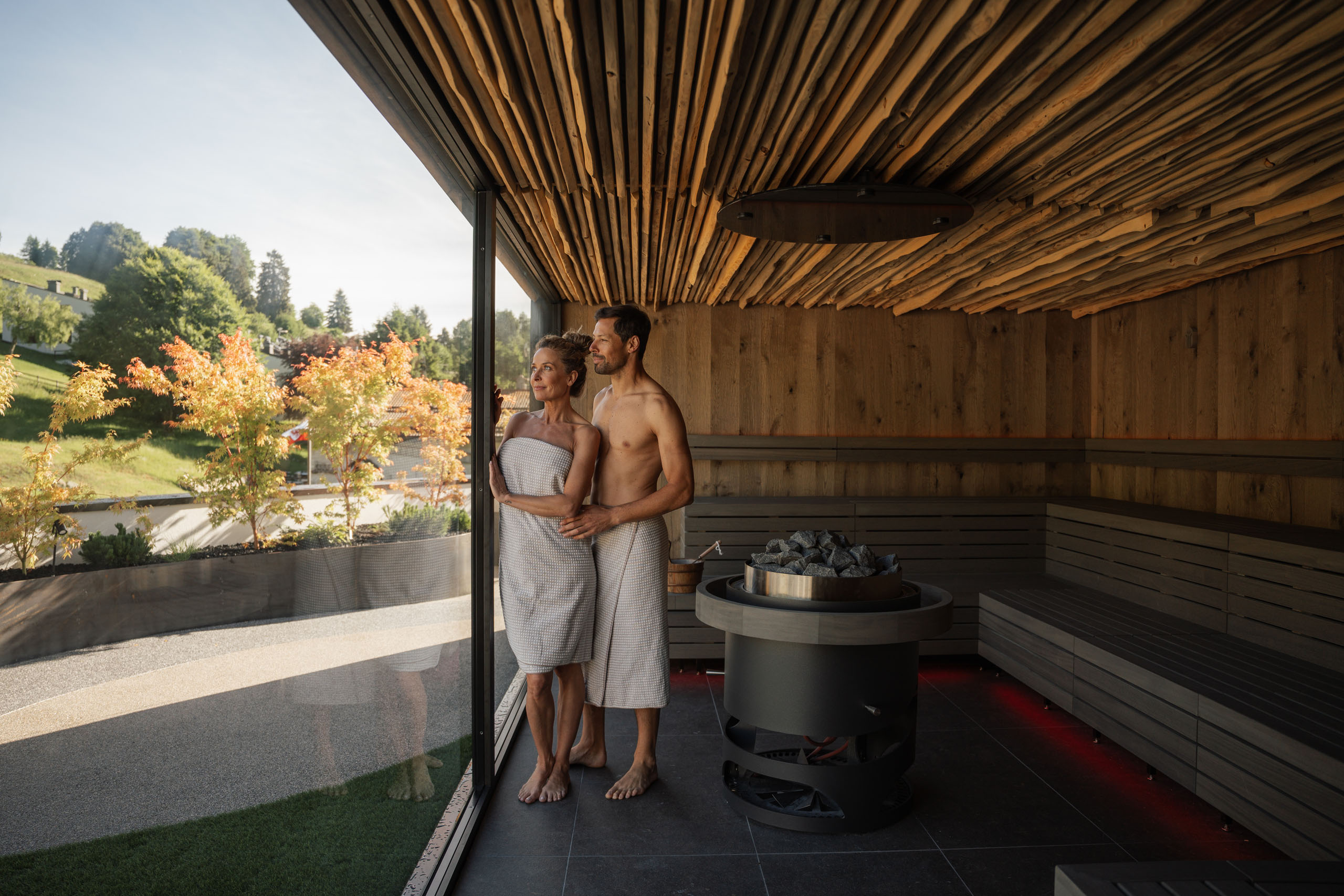 Le foto dell’Elgus Nature Retreat Coppia in accappatoi nella sauna con vista sul paesaggio autunnale