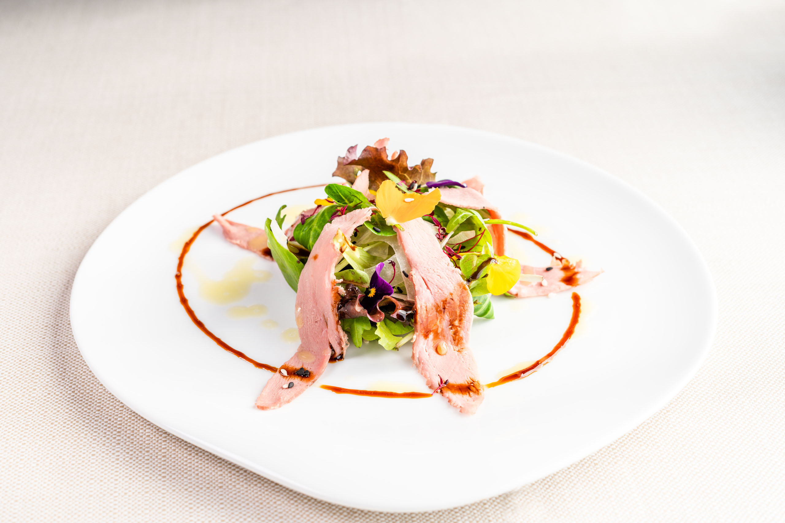 Le foto dell’Elgus Nature Retreat Insalata gourmet con fette di carne e decorazioni di fiori commestibili