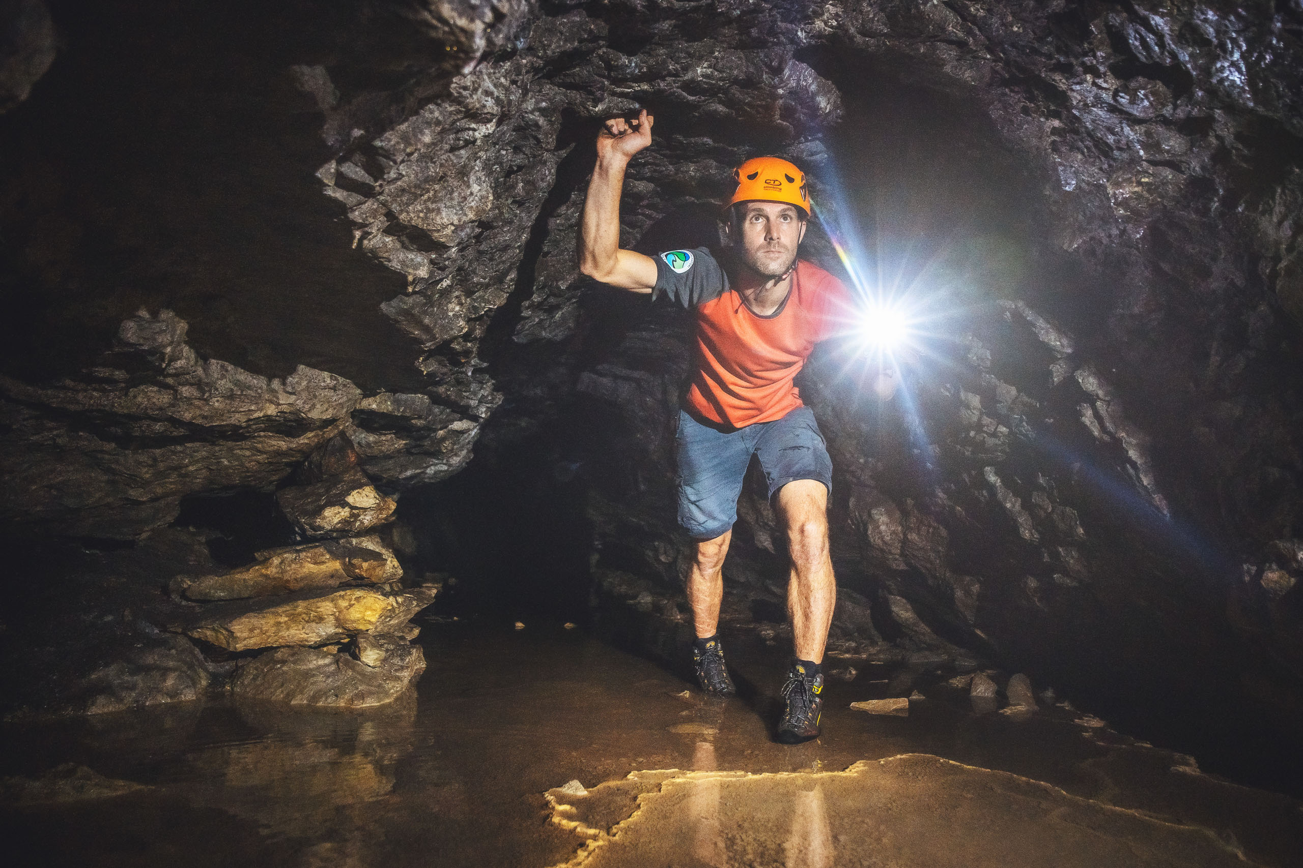 Le foto dell’Elgus Nature Retreat Uomo con casco arancione esplora una grotta con torcia